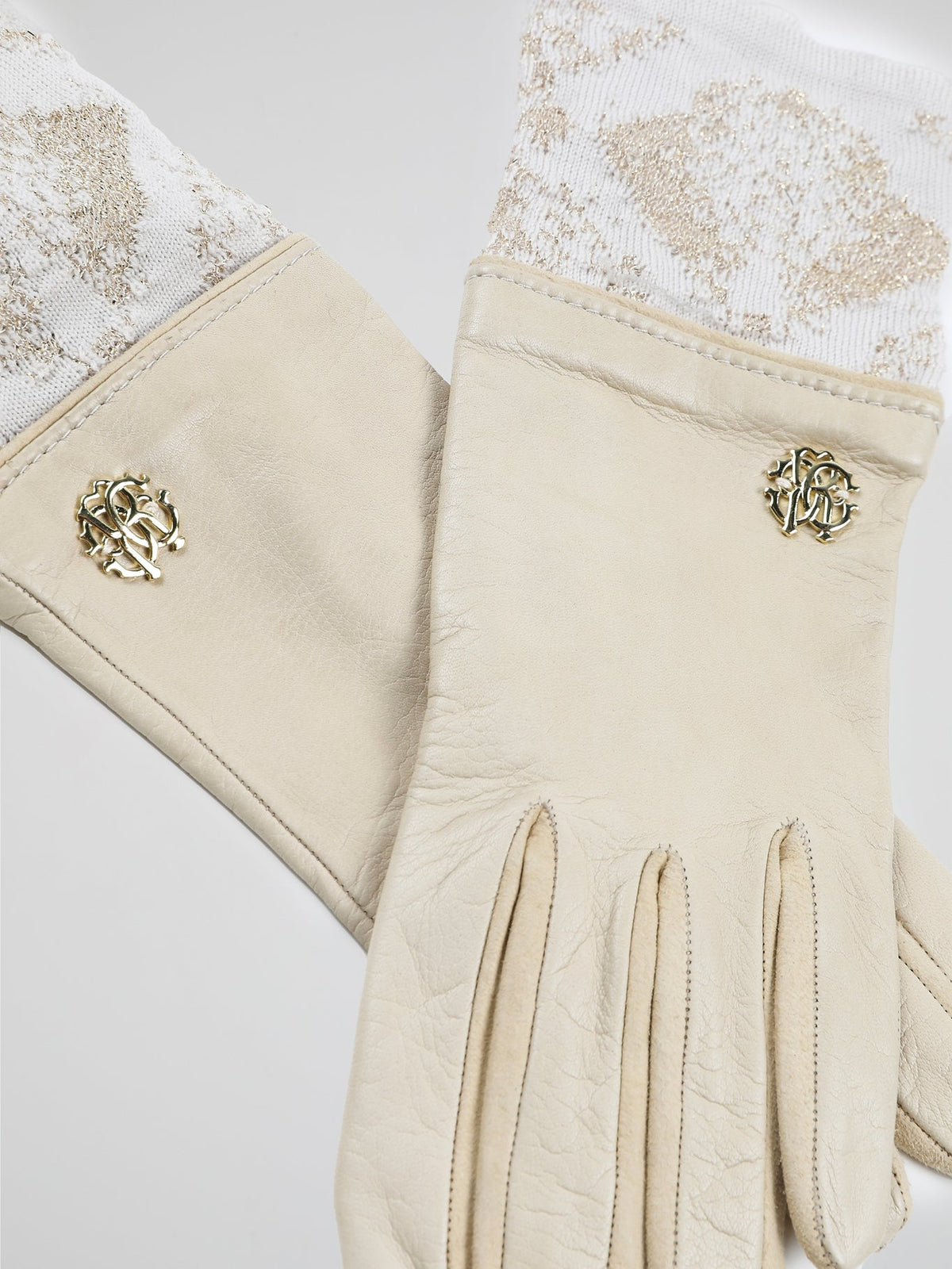 Step into luxury with these exquisite Beige Logo Embellished Gloves by Roberto Cavalli. Crafted with precision and elegance, these gloves feature the iconic Roberto Cavalli logo tastefully embellished on the fine beige leather. Whether you're strolling through the city or attending a glamorous event, these gloves will add a touch of opulence and sophistication to any outfit.