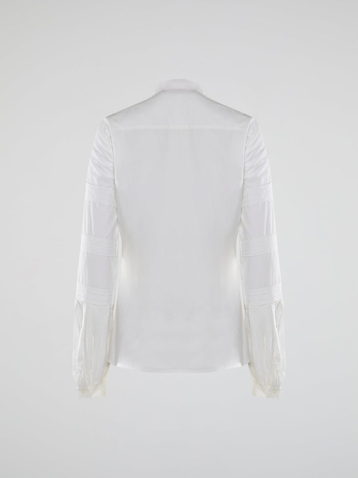 Step into the world of timeless elegance with the White Pleated Bib Shirt from Roberto Cavalli. Crafted with meticulous attention to detail, this masterpiece combines effortless sophistication with a touch of whimsical charm. From its delicate pleated bib to its crisp white fabric, this shirt will make a statement in any setting, exuding refined elegance that is truly captivating.