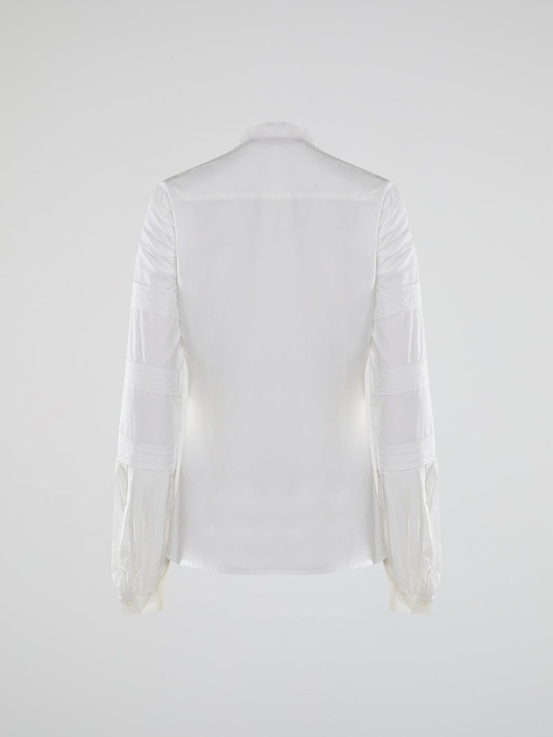 Step into the world of timeless elegance with the White Pleated Bib Shirt from Roberto Cavalli. Crafted with meticulous attention to detail, this masterpiece combines effortless sophistication with a touch of whimsical charm. From its delicate pleated bib to its crisp white fabric, this shirt will make a statement in any setting, exuding refined elegance that is truly captivating.