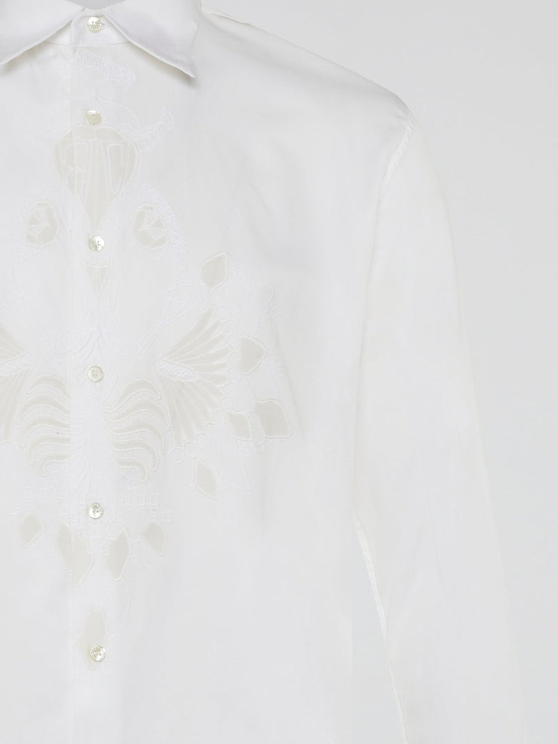 Step into a realm of elegance with the White Embroidered Shirt by Roberto Cavalli, where classic sophistication meets modern charm. Crafted with meticulous attention to detail, this shirt showcases exquisite floral embroidery that dances gracefully across the pristine white fabric. Embrace your inner fashion icon as you effortlessly blend timeless style with a touch of Italian flair, making a statement that is as timeless as it is enchanting.